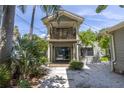 Two-story house with balcony and lush landscaping at 516 Gulf Blvd, Indian Rocks Beach, FL 33785