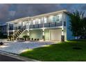 Two-story house with lighted staircase and landscaping at 83 Palm Blvd, Dunedin, FL 34698