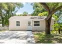Quaint house with a gravel driveway and mature trees at 4000 7Th N Ave, St Petersburg, FL 33713