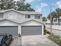 Gray two-story townhouse with attached garage and landscaped front yard at 9247 Jakes Path, Largo, FL 33771