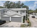Gray two-story townhouse with attached garage and landscaped front yard at 9247 Jakes Path, Largo, FL 33771