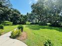 Lush green grounds with mature trees and a walking path at 400 N Bayshore Blvd # 104, Clearwater, FL 33759