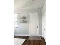 Bright entryway with dark hardwood floors, decorative shelves, and a white door at 1301 22Nd N Ave, St Petersburg, FL 33704