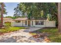 Well-maintained home with a tree-lined front yard and gated driveway at 135 Se Monroe N Cir, St Petersburg, FL 33703