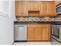 Kitchen features wood cabinets, granite countertops, stainless steel appliances, and tile backsplash at 3300 Fox Chase N Cir # 231, Palm Harbor, FL 34683