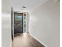 Bright hallway with wood-look flooring and access to balcony at 1933 Golfview Dr # 1933, Tarpon Springs, FL 34689