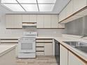 White kitchen with a double sink and a GE stove at 1933 Golfview Dr # 1933, Tarpon Springs, FL 34689