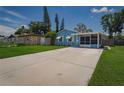 Front view of a light blue house with a driveway and a yard at 358 51St N Ave, St Petersburg, FL 33703