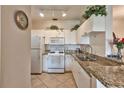 White kitchen with granite countertops and stainless steel appliances at 2732 Via Murano # 526, Clearwater, FL 33764