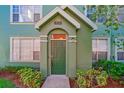 Green two-story townhome with a welcoming front door and landscaping at 9028 Lake Chase Island Way, Tampa, FL 33626
