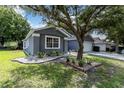 Gray house with white garage door and landscaping at 5204 New Brittany Ln, Zephyrhills, FL 33541
