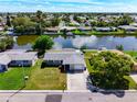 An aerial view of a single Gathering home on a canal with lush landscaping at 2248 Society Dr, Holiday, FL 34691