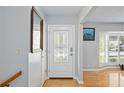 Bright entryway with hardwood floors, white door, and mirror at 13532 Alpine Ave, Seminole, FL 33776