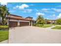 Two-story house with three-car garage, basketball court, and lush landscaping at 4508 Grand Lakeside Dr, Palm Harbor, FL 34684