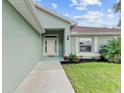 Front entry with walkway leading to a light teal home at 105 Dartmouth Rd, Venice, FL 34293
