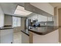 Kitchen features gray countertops, white cabinets and tile backsplash at 106 Pine Ct # 106, Oldsmar, FL 34677