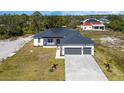 An aerial view of a well-maintained home with a three-car garage and an expansive green lawn at 14346 San Domingo Blvd, Port Charlotte, FL 33981