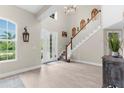 Bright foyer featuring a staircase, wood floors, and a high ceiling with chandelier at 32924 Estate Garden Dr, Wesley Chapel, FL 33545