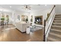 Bright living room with hardwood floors, modern furniture, and a staircase leading to the upper level at 13929 Lake Fishhawk Dr, Lithia, FL 33547