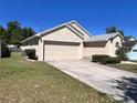 This single-Gathering home features a two-car garage, driveway, and well-kept lawn and landscaping at 418 Henderson Ave, Seffner, FL 33584