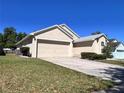 This single-Gathering home features a two-car garage, driveway, and well-kept lawn and landscaping at 418 Henderson Ave, Seffner, FL 33584