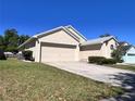 This single-Gathering home features a two-car garage, driveway, and well-kept lawn and landscaping at 418 Henderson Ave, Seffner, FL 33584