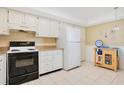 Functional kitchen featuring white cabinets, black appliances, and neutral countertops at 12200 Vonn Rd # 1209, Largo, FL 33774