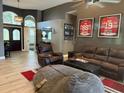Spacious living room featuring comfortable leather furniture, sports memorabilia and an open floor plan at 4749 Stoneview Cir, Oldsmar, FL 34677