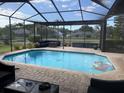 Backyard oasis with a sparkling pool, outdoor furniture, screened enclosure and relaxing water feature views at 4749 Stoneview Cir, Oldsmar, FL 34677