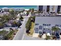 Aerial view of light blue two-story townhouses near white sand and the ocean at 900 Harbour House Dr, Indian Rocks Beach, FL 33785