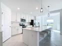 Modern kitchen with white cabinets, stainless steel appliances, island with seating, and stylish pendant lights at 14204 Heritage Landing Blvd # 714, Punta Gorda, FL 33955
