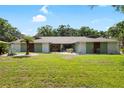 Inviting single-story home featuring manicured lawn, mature trees, and beautiful landscaping, providing great curb appeal at 4301 Hudson Ln, Tampa, FL 33618