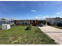 Cozy single-story home featuring a metal roof, a well-kept lawn, and convenient driveway at 29146 Tamayo Dr, Punta Gorda, FL 33982