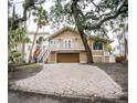 Two-story home with a balcony, stairs, a two car garage and a long paved driveway at 5169 Oxford Dr, Sarasota, FL 34242