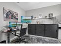 Modern home office with sleek black cabinets, dual monitors, and stylish decor accents at 7114 Mill Hopper Ct, Palmetto, FL 34221
