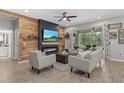 Cozy living room featuring a rustic wood accent wall, fireplace, and comfortable seating at 7114 Mill Hopper Ct, Palmetto, FL 34221