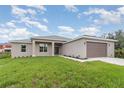 Beautiful single-story home featuring an attached garage, manicured lawn, and neutral-toned stucco exterior at 14362 San Domingo Blvd, Port Charlotte, FL 33981