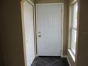 Front entry with tile flooring, coat closet, and window at 7410 Mayfield Dr, Port Richey, FL 34668
