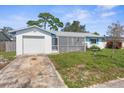 House exterior featuring a white single-story home with a garage and screened porch at 3125 Bigelow Dr, Holiday, FL 34691