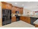 Spacious kitchen with dark wood cabinets, granite countertops, and black appliances at 1383 Dartford Dr, Tarpon Springs, FL 34688