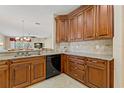 Kitchen with dark wood cabinets, granite countertops, and black appliances at 1383 Dartford Dr, Tarpon Springs, FL 34688