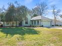 House exterior featuring a two-car garage and well-maintained lawn at 8440 Maybelle Dr, Weeki Wachee, FL 34613