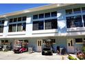Charming condo building with multiple windows and golf carts parked in front at 1873 Mazo Mnr # T5, Lutz, FL 33558