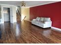 Open concept living room featuring wood floors, red accent wall and staircase at 1873 Mazo Mnr # T5, Lutz, FL 33558