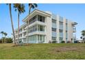 Charming exterior view of a multi-story building with blue accents and lush green lawn at 770 Island Way # N302, Clearwater, FL 33767