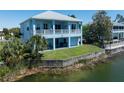 Back view of two story house with backyard and canal view at 3215 Hibiscus Dr, Hernando Beach, FL 34607