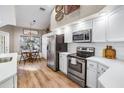 Bright kitchen featuring stainless steel appliances, white cabinets, and wood flooring at 11242 Riddle Dr, Spring Hill, FL 34609