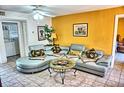 Living room with an L-shaped sofa, coffee table, and view into kitchen at 2077 Wetland Pt # 1202, Lutz, FL 33558
