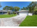 Gray house with white garage door and a large, grassy yard at 2639 Royal Ridge Dr, Spring Hill, FL 34606