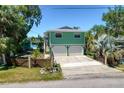 Two-story waterfront home featuring a two-car garage and lush landscaping at 6629 Harbor Dr, Hudson, FL 34667